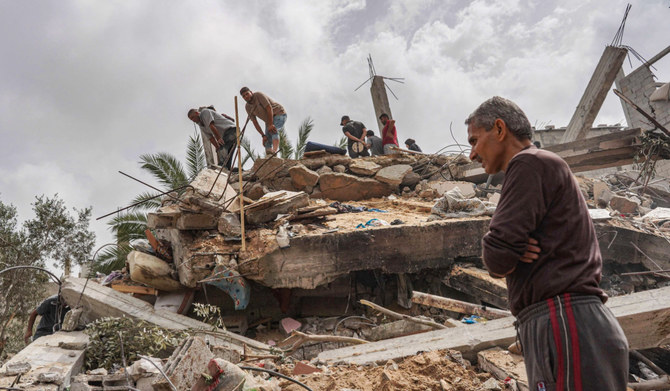 イスラエルとハマスとの紛争が続く中、2024年5月11日、ガザ地区中央部のアル・ザウェーダで、イスラエルの攻撃で破壊された住宅の瓦礫を確認するパレスチナ人。(AFP＝時事）