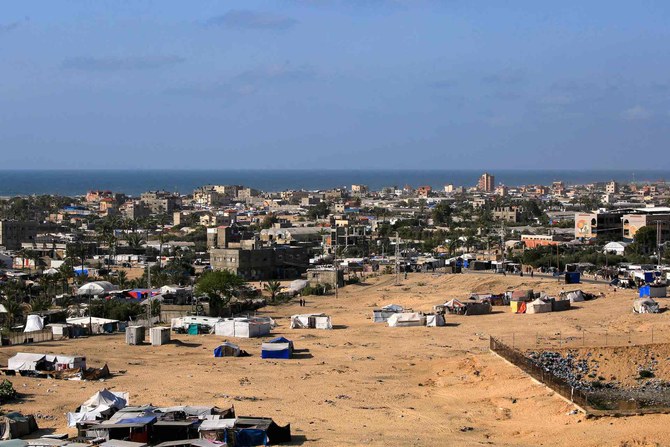 2024年5月26日、イスラエルと過激派組織ハマスの紛争が続く中、ガザ地区南部のラファで破壊された建物の前を歩くパレスチナ人男性。(写真:Eyad BABA / AFP)