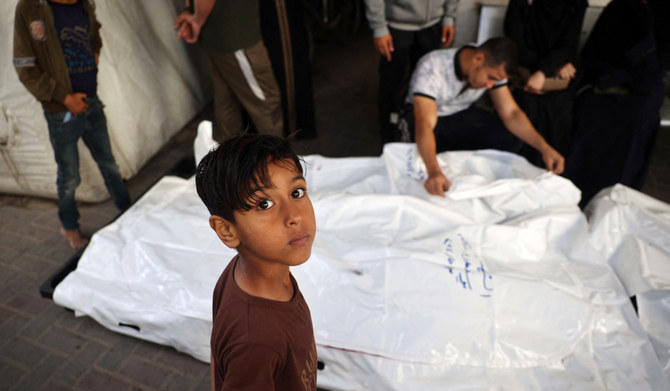 イスラエルとハマスの対立が続く中、2024年5月3日、ガザ地区南部ラファのアルナジャール病院の庭で、イスラエル軍の爆撃で死亡したパレスチナ人の親族が遺体のそばで嘆き悲しむ姿を見つめる少年。(AFP）