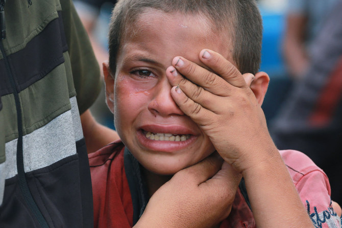 2024年6月3日、ガザ地区中部で前夜イスラエルの空爆で死亡した父親の葬儀で涙を流す避難民のパレスチナ人少年。(AFP=時事)