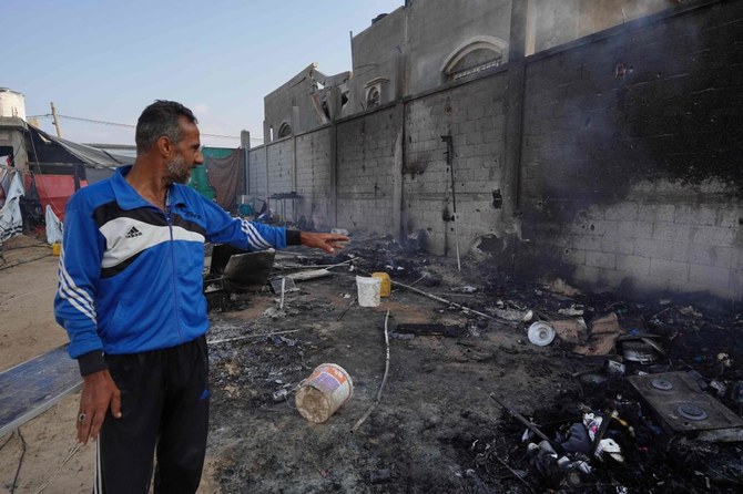 2024年6月22日、イスラエルとパレスチナ過激派組織ハマスの対立が続く中、パレスチナの都市ラファ北西部のアルマワシ地区を空爆した翌日、テント地で灰を指差すパレスチナ人男性。(AFP＝時事）