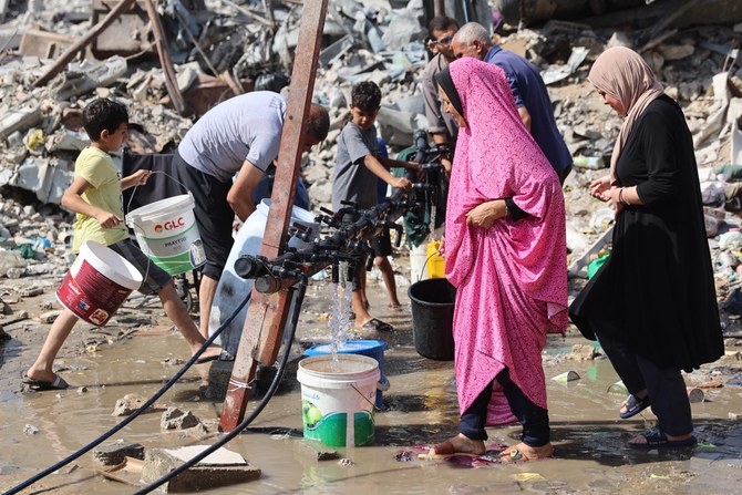 ガザ地区北部のジャバリア難民キャンプで、スタンドパイプから水を汲むパレスチナ人。(AFP＝時事）