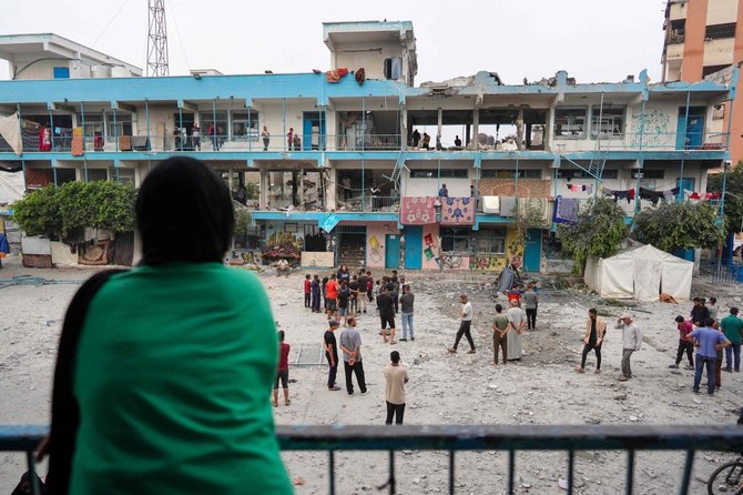 2024年6月6日、イスラエルとパレスチナの過激派組織ハマスとの間で紛争が続く中、ガザ地区中部のヌセイラートで、イスラエル軍の砲撃で被災した避難民を収容する国連学校をチェックするパレスチナ人。(AFP=時事)