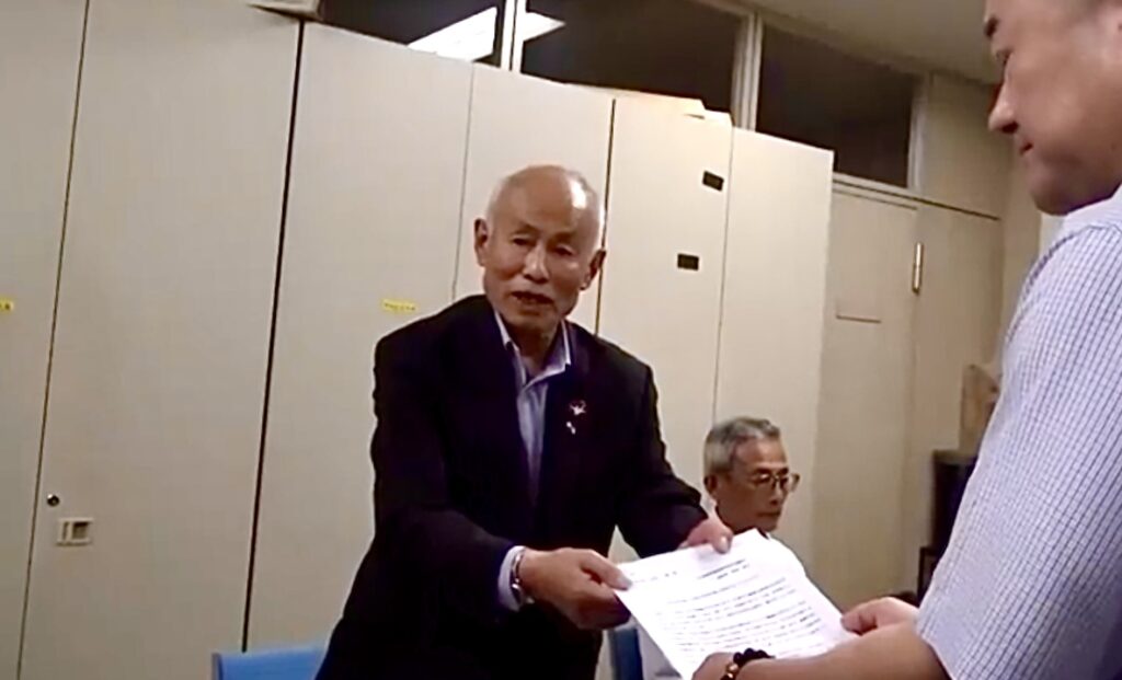 広島市職員に抗議文を手渡す広島県原爆被害者の会の箕牧智之会長。(TBS)