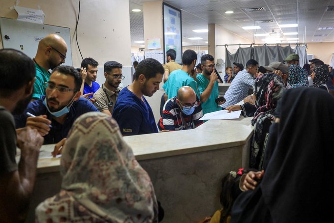 イスラエルとパレスチナ・ハマスの紛争が続く中、2024年7月3日、ガザ地区南部のハーン・ユーニスで、イスラエル軍の避難命令を受けて欧州ガザ病院から患者が移送された後、ナーセル病院に立つパレスチナ人医療関係者と市民。(AFP=時事)