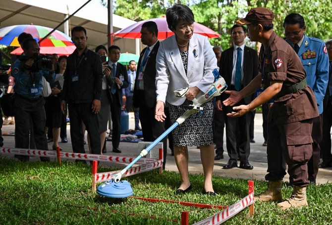 2024年7月6日、プノンペンのカンボジア地雷対策センター（CMAC）を訪問した上川陽子外相（C）は、地雷探知機を手に地雷除去作業員（右）と会談した。(AFP)