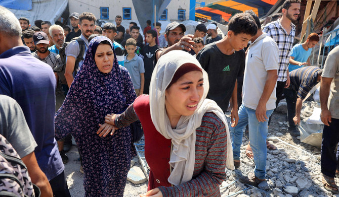 2024年7月14日、イスラエルとパレスチナ過激派組織ハマスの紛争が続く中、ガザ地区中央部のヌセイラット難民キャンプで、イスラエル軍がUNRWA（国連パレスチナ難民救済事業機関）運営のアブアラバン学校を砲撃した後、反応するパレスチナ人女性。(AFP＝時事）