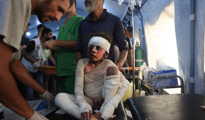 2024年7月14日、イスラエルとパレスチナ過激派組織ハマスの対立が続く中、ガザ地区中部のヌセイラット・キャンプで、UNRWA（国連パレスチナ難民救済事業機関）が運営するパレスチナ人国内避難民が暮らす避難所と化したアブ・アラバン学校がイスラエル軍の砲撃を受け、負傷したパレスチナ人少女がヌセイラット難民キャンプのアル・アウダ病院で手当てを受けている。(AFP＝時事）