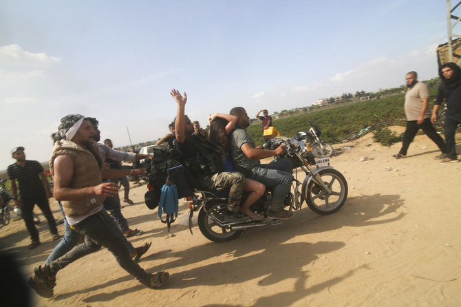2023年10月7日、イスラエル南部での攻撃中、捕虜となったイスラエル市民をバイクでガザ地区へ運ぶパレスチナ人。(APファイル写真)