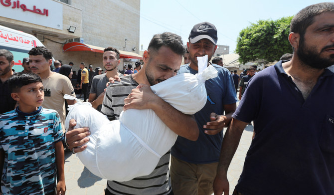 イスラエルとハマスが対立する中、ガザ地区中心部のデイル・アル・バラにあるアル・アクサ殉教者病院で、遺体を運ぶパレスチナ人男性（2024年7月27日撮影）。(REUTERS)