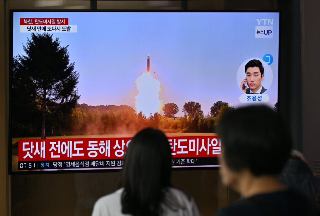 2024年7月1日、ソウルの駅で、北朝鮮のミサイル発射実験に関するニュース映像を映し出すテレビ画面を見る人々。(AFP=時事)