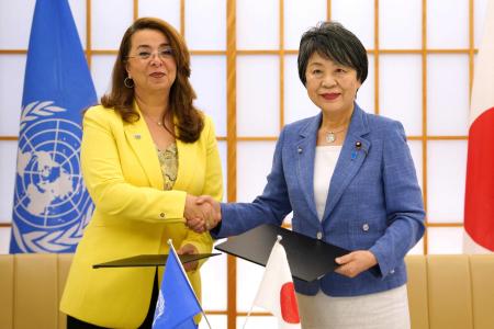2024年7月4日、東京の外務省で行われたアフガニスタン無償資金協力に関する交換公文調印式で握手する上川陽子外相（右）と国連薬物犯罪事務所（UNODC）のガーダ・ワリー事務局長。(AFP)