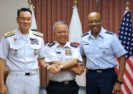 (左から）日米韓首席幕僚会議で握手を交わす韓国統合参謀本部の金明秀議長、制服組トップの自衛隊の吉田義秀幕僚長、米統合参謀本部のチャールズ・Q・ブラウン・ジュニア議長（2024年7月18日、東京・防衛省で）。(AFP)