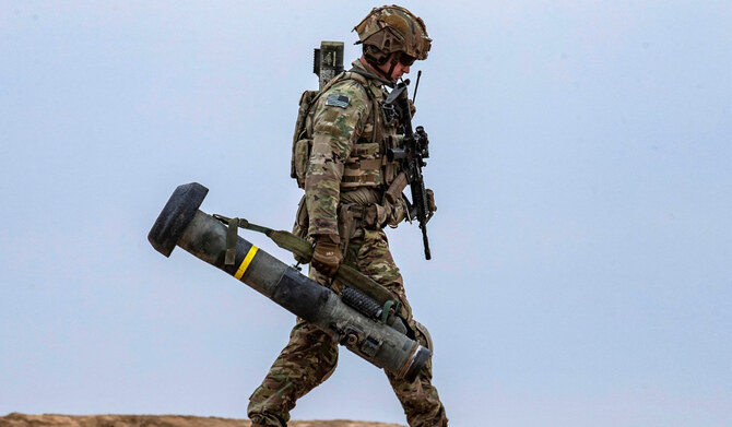 2021年12月7日、シリア北東部ディール・エゾールの田園地帯で行われた、シリア民主軍(SDF)と米国主導の国際連合軍によるダーイシュ組織に対する合同軍事演習で、ジャベリン地対空ミサイルランチャーを持って歩く米軍兵士。(AFP)
