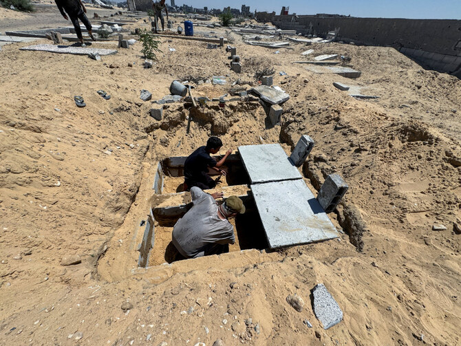 2024年8月15日、イスラエルとハマスの戦争が激化する中、ガザ地区南部のハーン・ユーニスの墓地で墓の準備をするパレスチナ人。(REUTERS)
