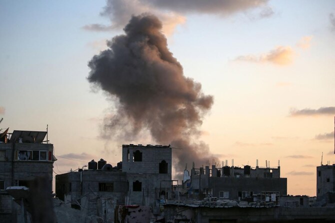 2024年8月22日、ガザ地区中央部のヌセイラット難民キャンプで、イスラエル軍が建物を標的にして煙が上がる。(AFP=時事)