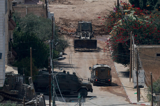 イスラエル占領下のヨルダン川西岸地区ジェニンで、イスラエル軍の襲撃を受ける治安部隊の車両。(ロイター）