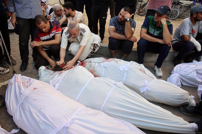 2024年8月10日、ガザ市のパレスチナ人避難民を保護する学校で90人以上が死亡したイスラエル軍の空爆後、アル・マーマダニ病院で覆いかぶさった家族の遺体を悼む人々。(ファイル/AFP)