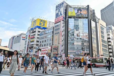 2024年8月13日、東京都心新宿区の交差点を横断する歩行者。(AFP=時事)