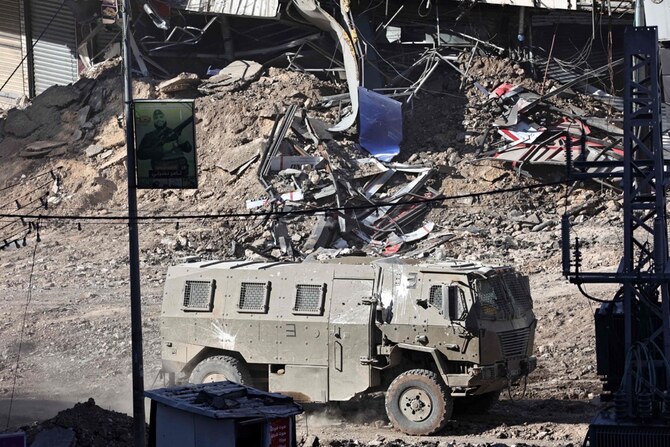 ヨルダン川西岸地区の荒廃した道路を走るイスラエルの装甲車。(AFP=時事)