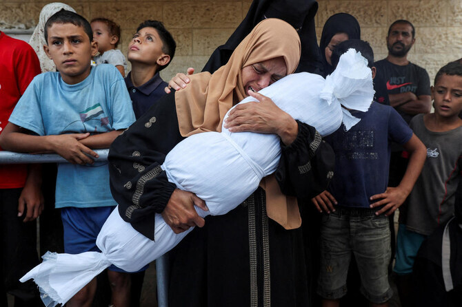 イスラエルとハマスの紛争中、イスラエルの攻撃により死亡したパレスチナ人アル・ドゥラ一家の子供を抱える親族。ガザ地区中央部のデイル・アル・バラにあるアル・アクサ殉教者病院にて。(ファイル/ロイター)