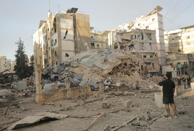 2024年10月4日、ベイルート南部郊外のメイジュ地区に対するイスラエルの空爆の後、ヒズボラとイスラエル間の国境を越えた敵対行為の中、人々は被害状況を調査した。(ロイター)