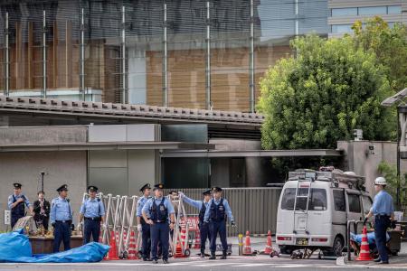 2024年10月19日、東京都心にある首相官邸の外でバリケードに衝突した車両を警察官が調べている。男が与党本部ビルの外で火炎瓶のようなものを投げ、機動隊の車両に衝突した後、バリケードに突っ込んだ。(AFP)