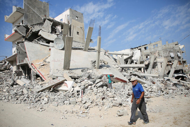 イスラエル軍の攻撃中、イスラエル・ハマス紛争中の2024年11月6日、ガザ地区南部のハーン・ユーニスで、以前の攻撃で破壊された家の瓦礫の横を歩くパレスチナ人男性。（ファイル/ロイター）