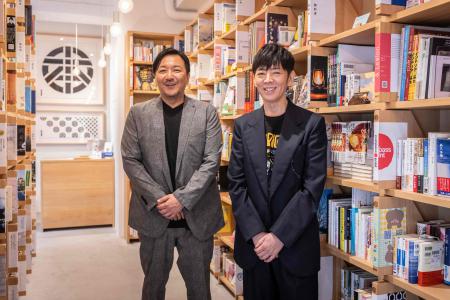 この写真は2024年7月18日、東京にある書店「本丸神保町」で、店主で小説家の今村昌吾氏(左)とクリエイティブディレクターの佐藤可士和氏が撮影に応じた。(AFP)