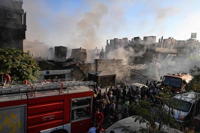 2024年11月14日、ダマスカスのマゼ地区で伝えられたイスラエルによる空爆の被害状況を確認する人々。(AFP)