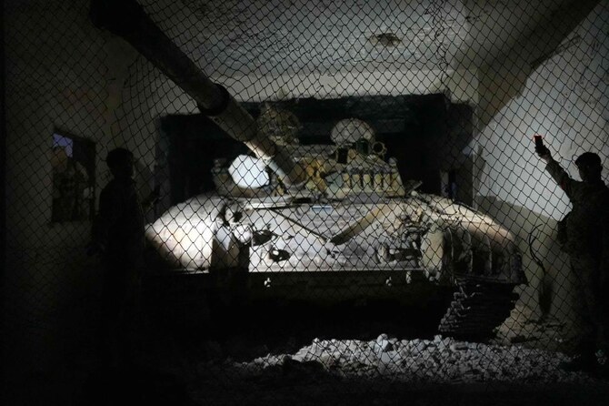 2024年12月1日、シリア北部の町ミナグの空港を占拠し、廃戦車を点検する反政府戦闘員たち。(AFP)