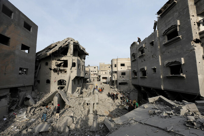 イスラエルとハマスが対立する中、ガザ地区中央部のヌセイラット難民キャンプで、イスラエルによる家屋への空爆の被害状況を視察するパレスチナ人（2024年12月7日撮影）。(ロイター）