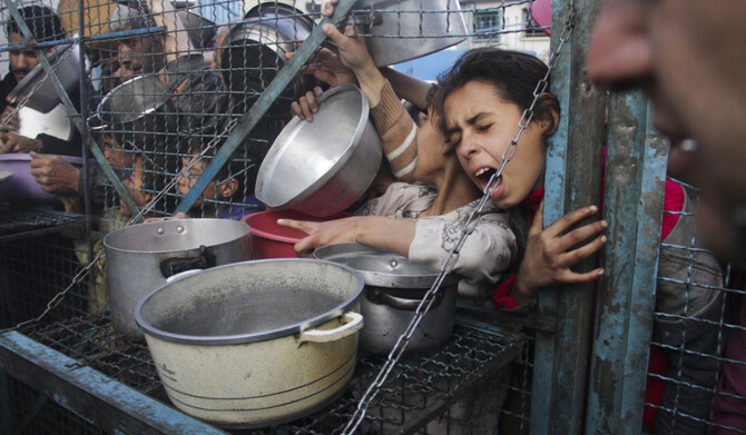 2024年3月18日、ガザ地区のジャバリヤ難民キャンプで、無料の食事を受け取ろうと並ぶパレスチナ人。(AP)