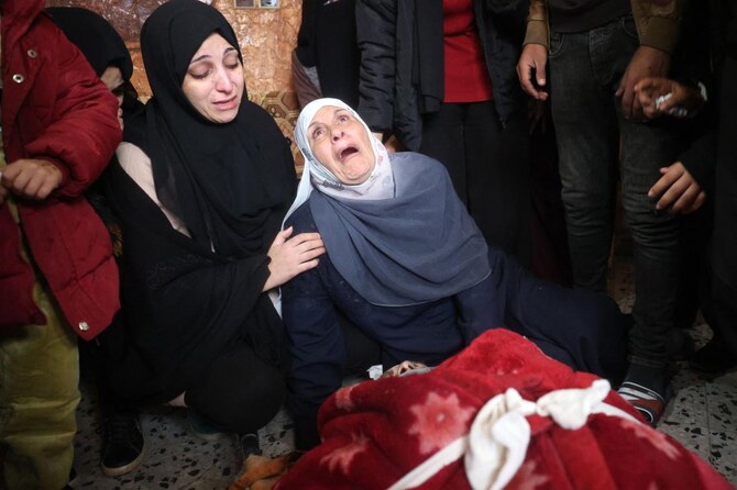 イスラエルとパレスチナ武装勢力の戦争が続く中、イスラエル軍の空爆で死亡した親族を悼むパレスチナ人。(AFP)