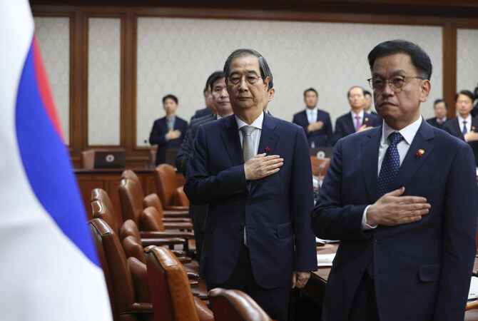 尹錫烈（ユン・ソクヨル）大統領の弾劾訴追後、国家指導者代行となった韓国の韓徳洙（ハン・ドクス）首相（右から2人目）は、2024年12月24日火曜日、韓国ソウルの政府複合施設で閣議中に敬礼した。(AP)