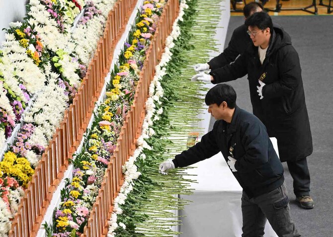 2024年12月30日、務安の務安運動公園で行われた済州航空機墜落事故の犠牲者追悼祭壇に参列する弔問客。(AFP)