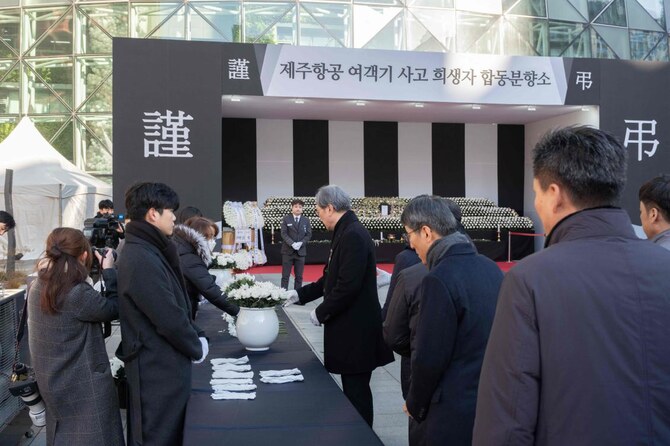 韓国は7日間の喪に服し、国旗は半旗で掲揚される。上の写真は、2024年12月31日、ソウル市庁舎前に設置された追悼碑の前に花を手向ける人々。(AFP)
