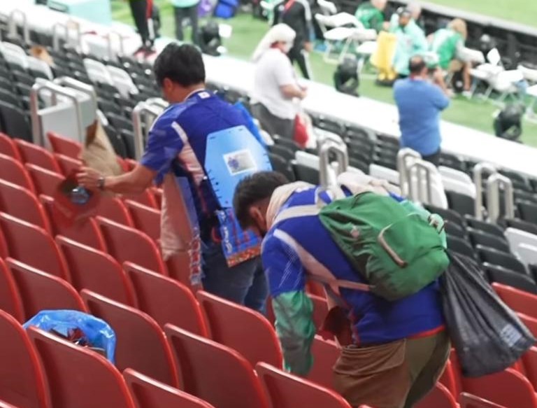 2022年のカタールでのFIFAワールドカップの試合後に、日本のファンがゴミ拾いをする様子。
