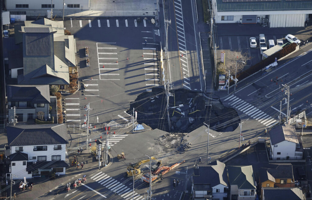 2025年1月30日木曜日、東京北東部の八潮市で、トラックが道路にできた陥没穴に落ちてから2日後、警察官と救助隊員が救助活動の準備をしている。(松田悠/共同通信 via AP)