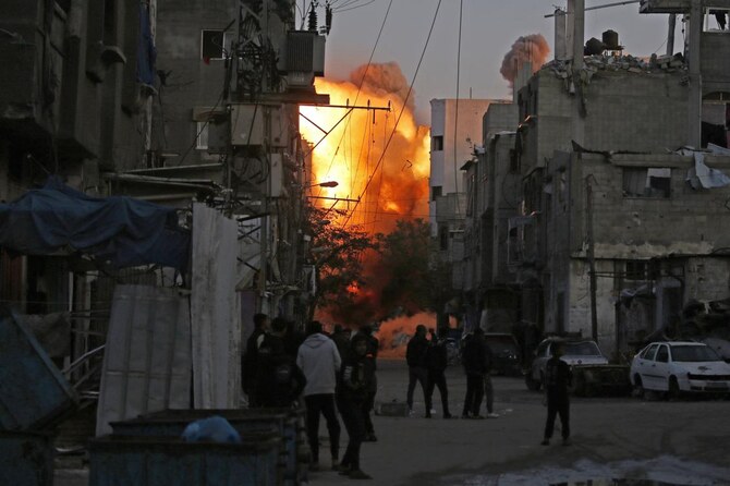 2025年1月12日、ガザ地区中部のパレスチナ難民キャンプ「ブレイジ」で、イスラエル軍の空爆により破壊された建物から煙が上がっている。(AFP=時事)