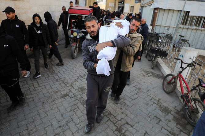 イスラエルとハマスの紛争が続く中、イスラエル軍の攻撃で死亡したパレスチナ人の遺体を運ぶ男たち（2025年1月13日、ガザ市のアル・アハリ・アラブ・バプティスト病院にて）。(REUTERS)
