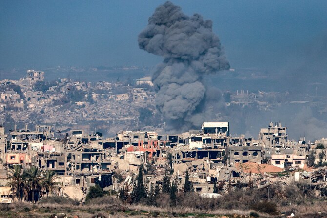 イスラエルとハマスの戦争が続く中、2025年1月13日、ガザ地区北部の破壊された建物の上空で、爆発から立ち上る煙がイスラエル側から撮影された写真。(AFP=時事)