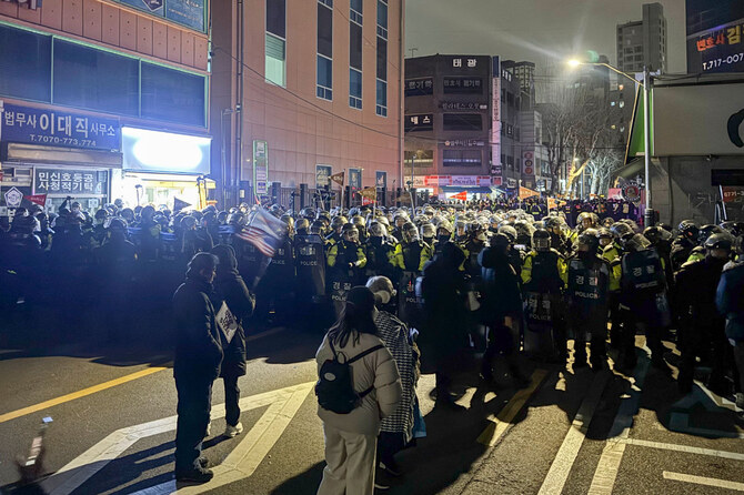 2025年1月19日未明、ソウルのソウル西部地裁近くの路上で警備する警察。弾劾された韓国大統領尹錫烈（ユン・ソクヨル）氏の勾留を延長した裁判所に入るため、数百人のデモ隊が窓ガラスを割ったり、ドアを壊したりした。(AFP＝時事）
