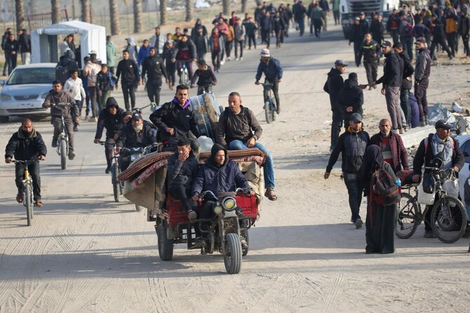 2025年1月19日、ガザ市の通り沿いで、パレスチナ国旗をあしらった車に乗る男性たち。(AFP＝時事）