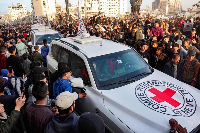 19日、ガザ市のサラヤ広場で、赤十字国際委員会（ICRC）の車両の周りに集まる人々。イスラエル軍は、赤十字が人質3人の引き渡しを確認したと発表した。(AFP＝時事)