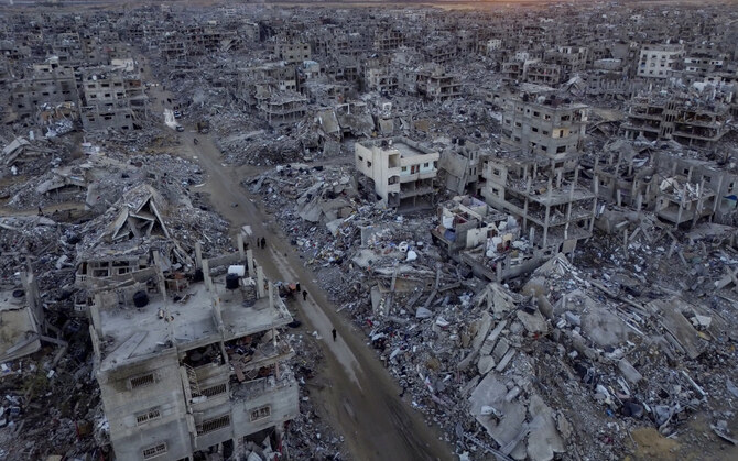 2025年1月24日、ガザ地区のラファで、イスラエル軍の空爆と地上攻撃による破壊の中を歩くパレスチナ人を撮影した航空写真。(AP=共同)