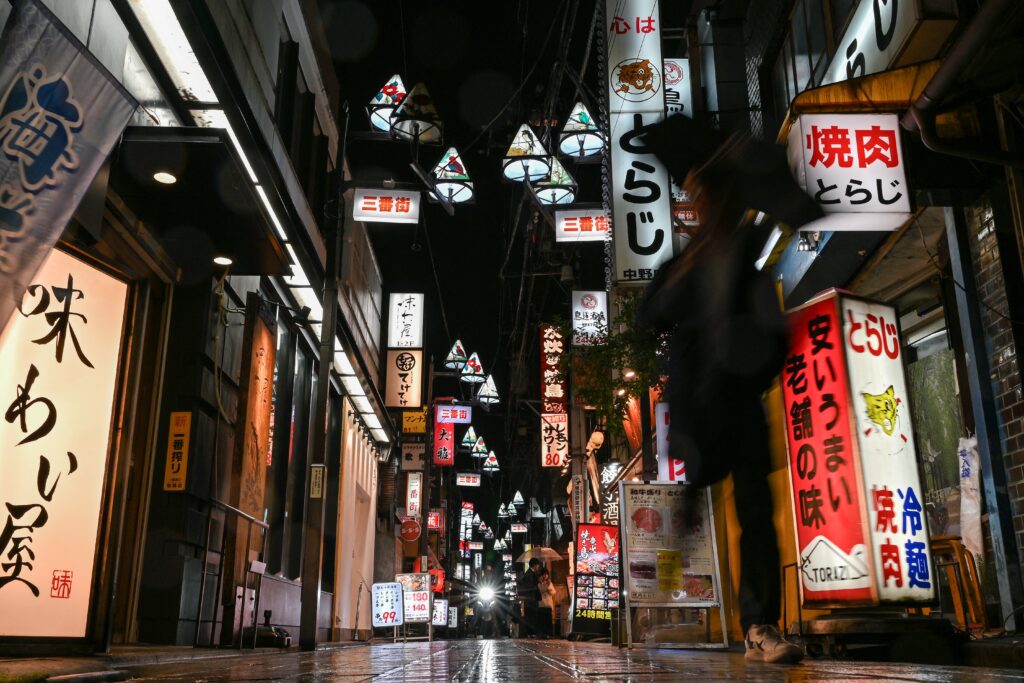 2024年11月20日、東京・中野の人気商業地区で、レストランを通り過ぎる人々。(AFP=時事)