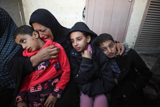 2025年1月14日、ガザ地区のDeir El-Balahにある避難所に対するイスラエルの空爆により死亡した親族を悼むパレスチナ人。(AFP)