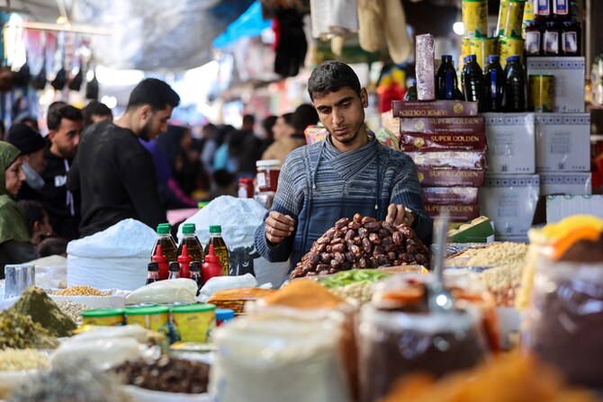 ガザ市の旧ザウィヤ市場でデートの約束をするパレスチナ人男性。(AFP＝時事）