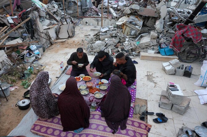 ラマダン期間中、ガザ地区北部のBeit Lahiaにあるテントの外で、家族と共にイフタールをするBeit Hanoun病院重症治療科のKhaled Mohammed Abu Jari医師(57)(左)。(AFP=時事)